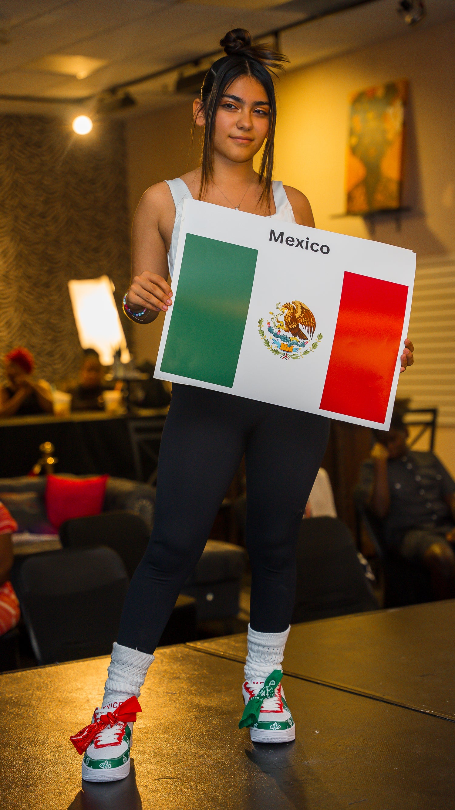 mexican girl with mexico flag sneakers on -- standing and holding mexico flag